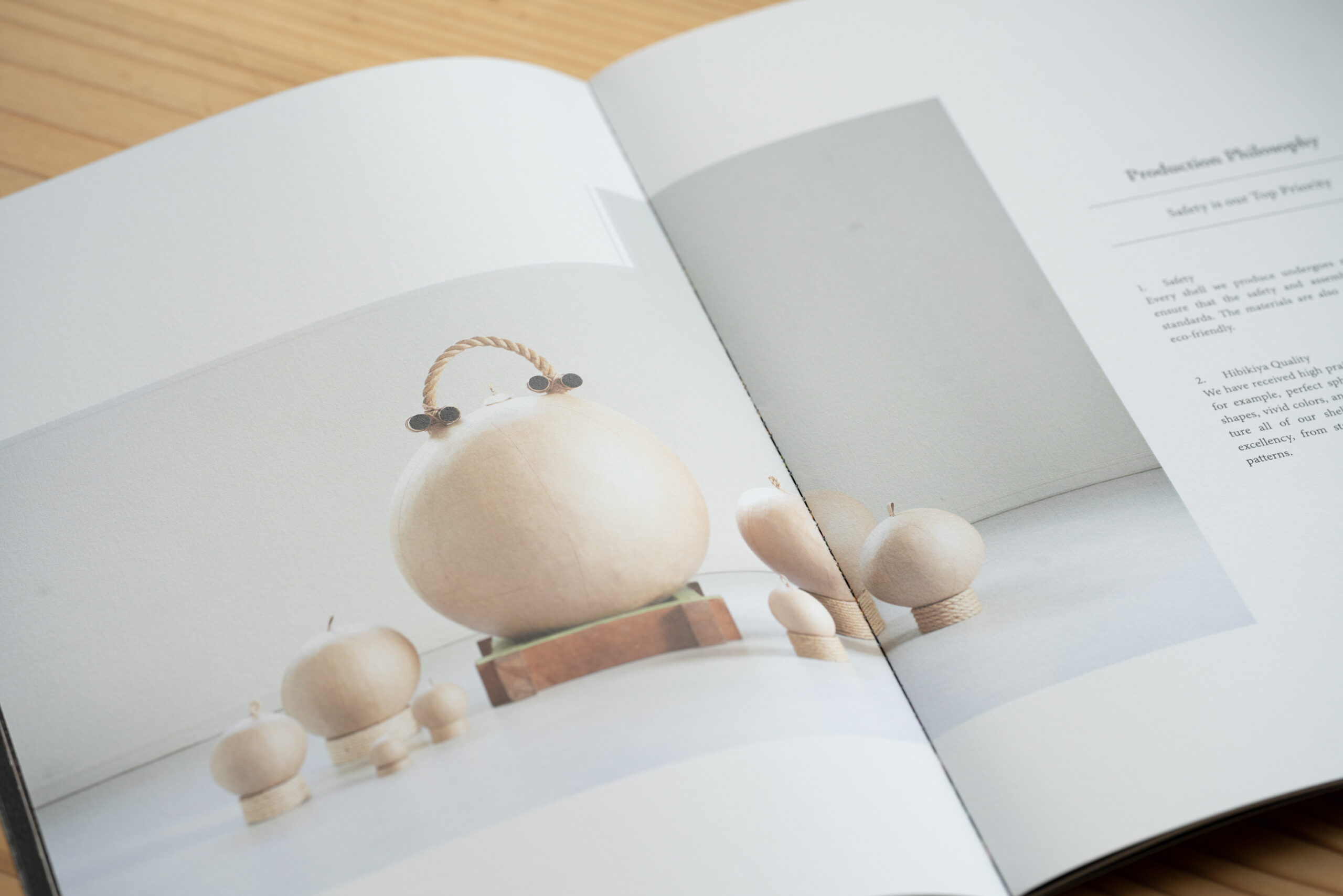 仕上がった花火玉が並ぶ静物写真と「Production Philosophy」のページ