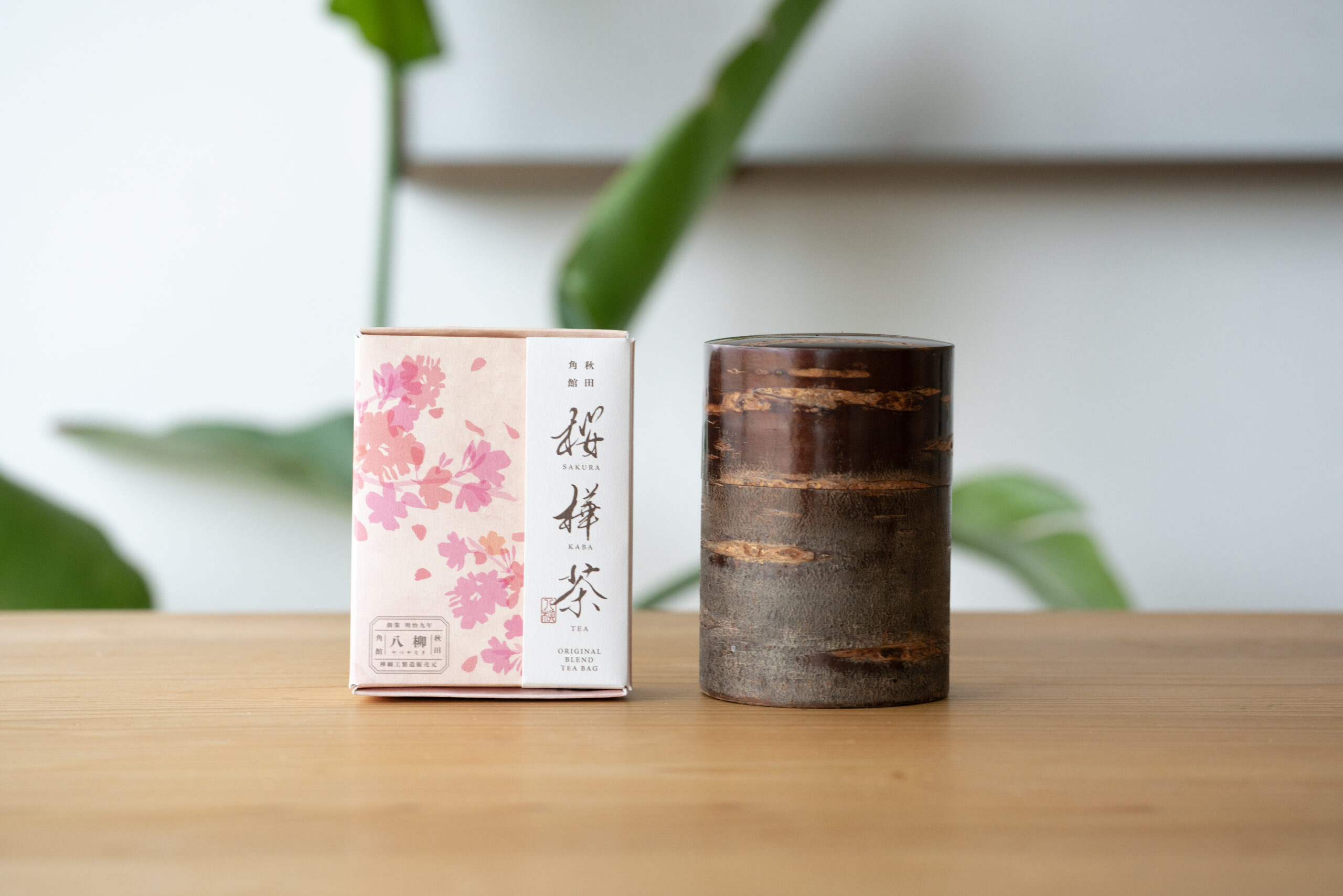 桜柄のパッケージ箱と樺細工の茶筒が並ぶ、桜樺茶の商品写真