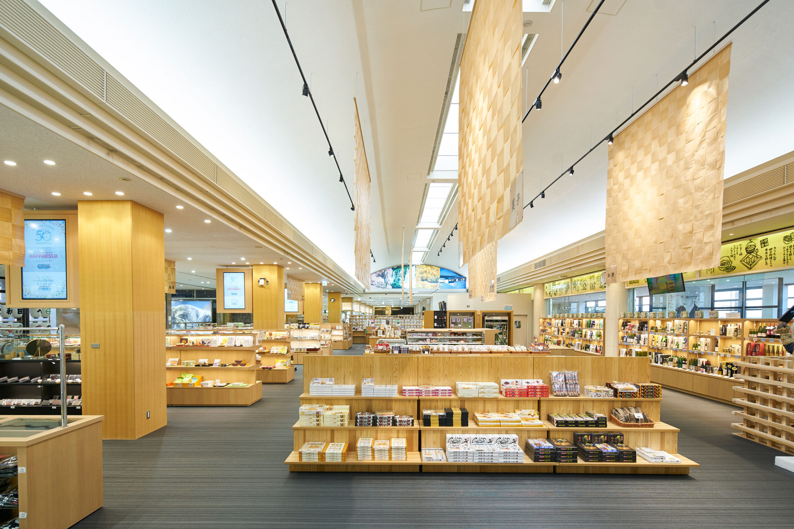 秋田杉のタペストリーが連なる売場通路の全景
