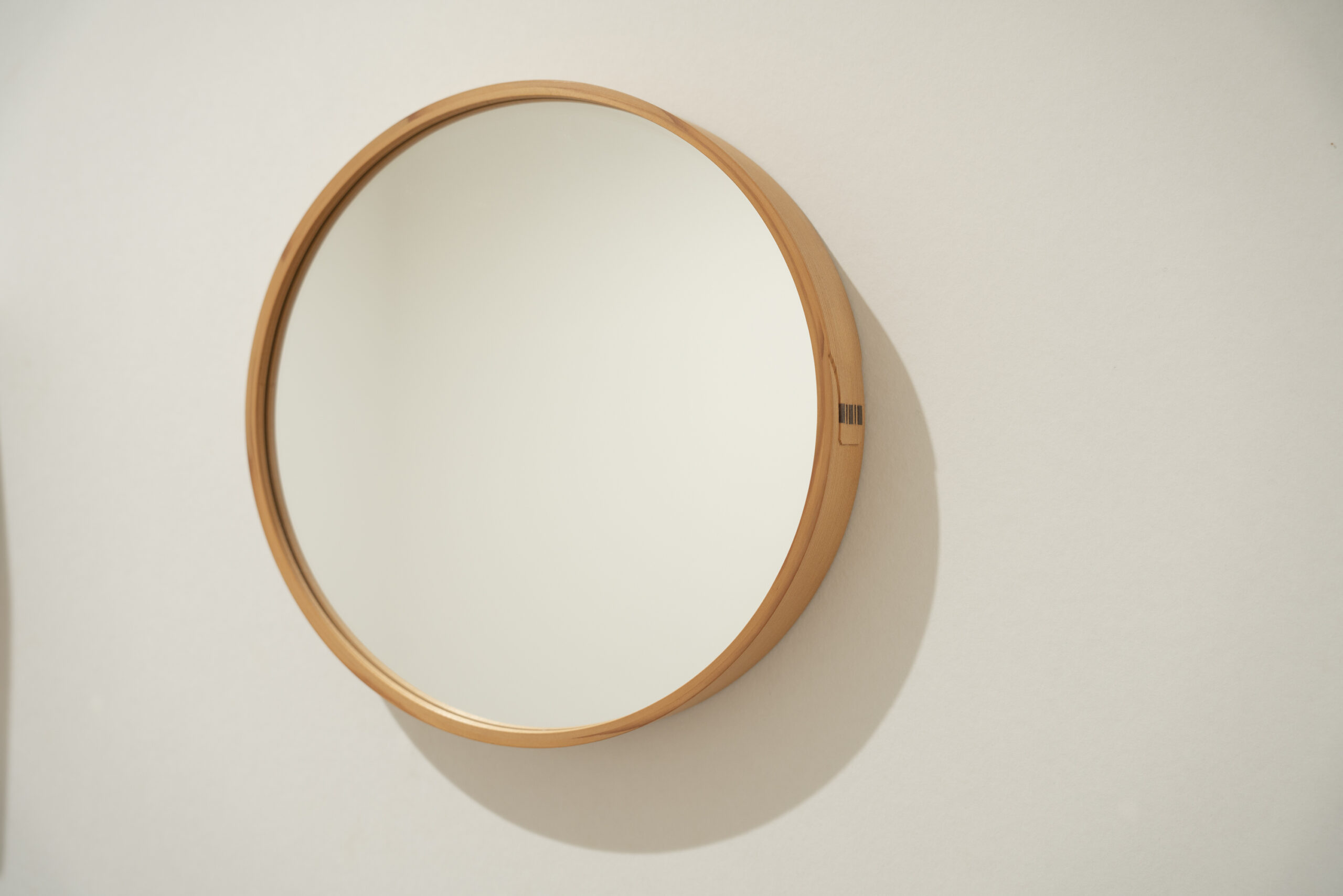 白い壁に掛けられたWa MIRRORと、柔らかく落ちる影