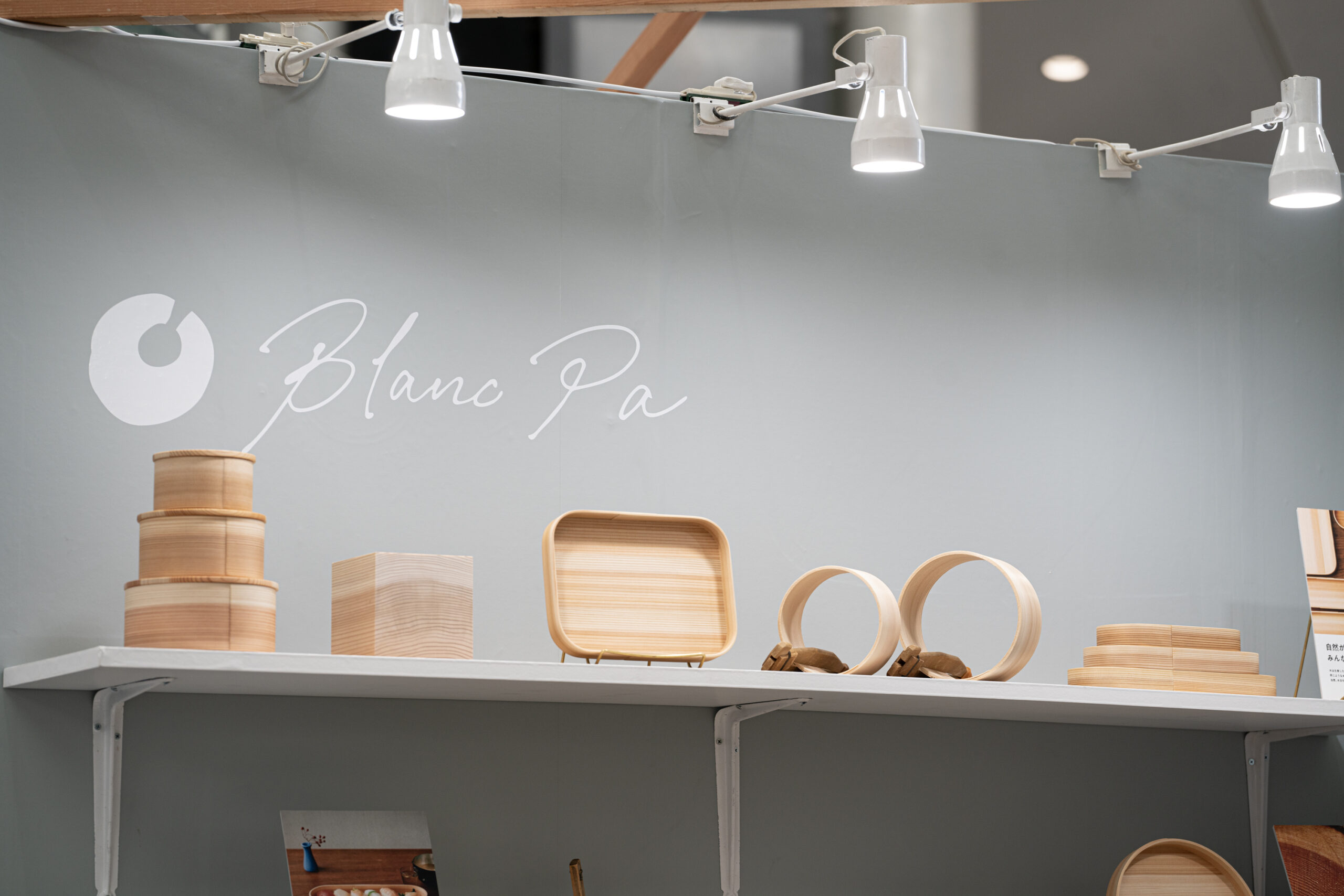 壁面に描いたBlanc Paのロゴタイプと、棚に並ぶ木地のプロダクト