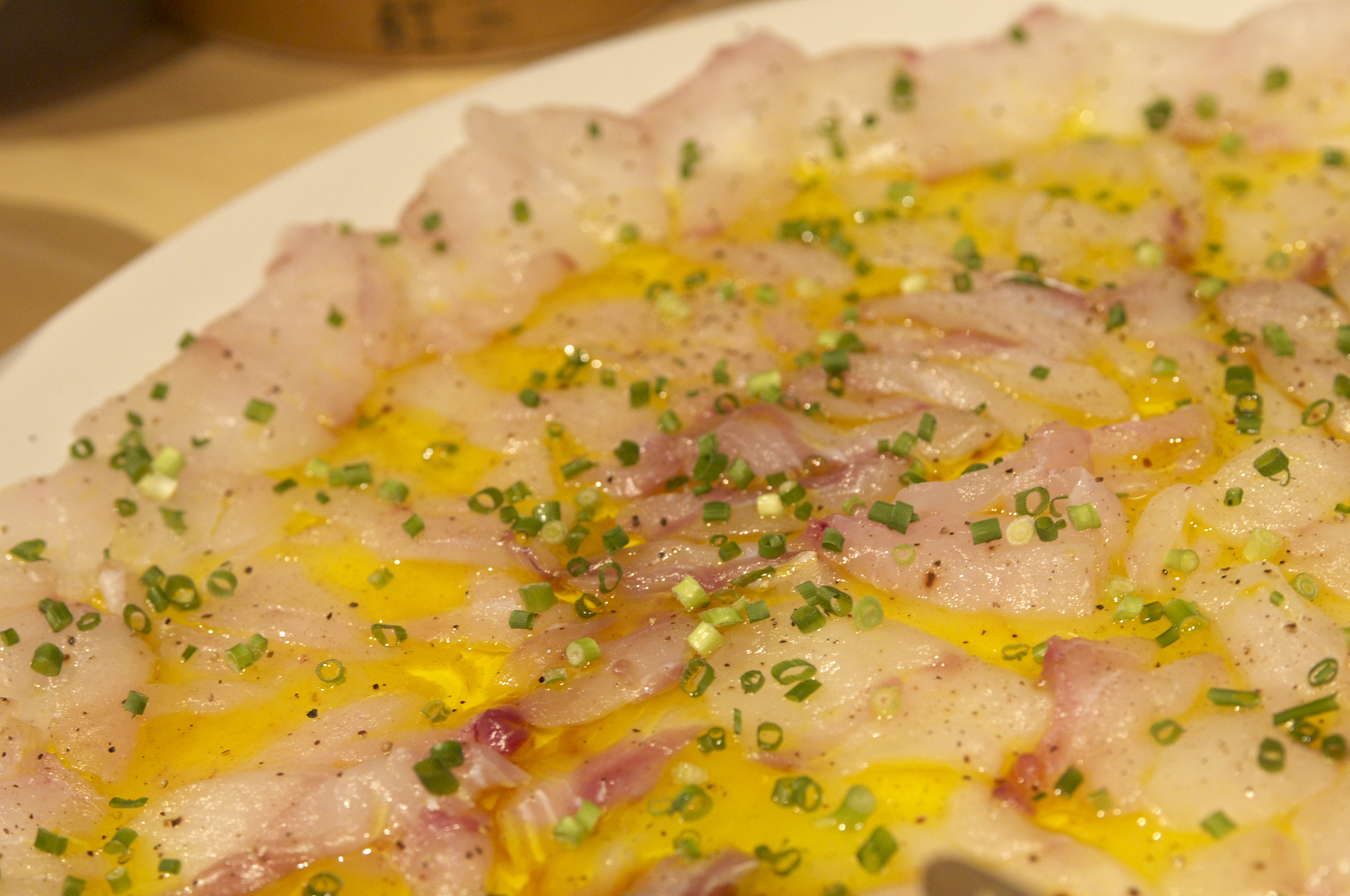 オリーブオイルと万能ねぎを添えた鯛のカルパッチョ
