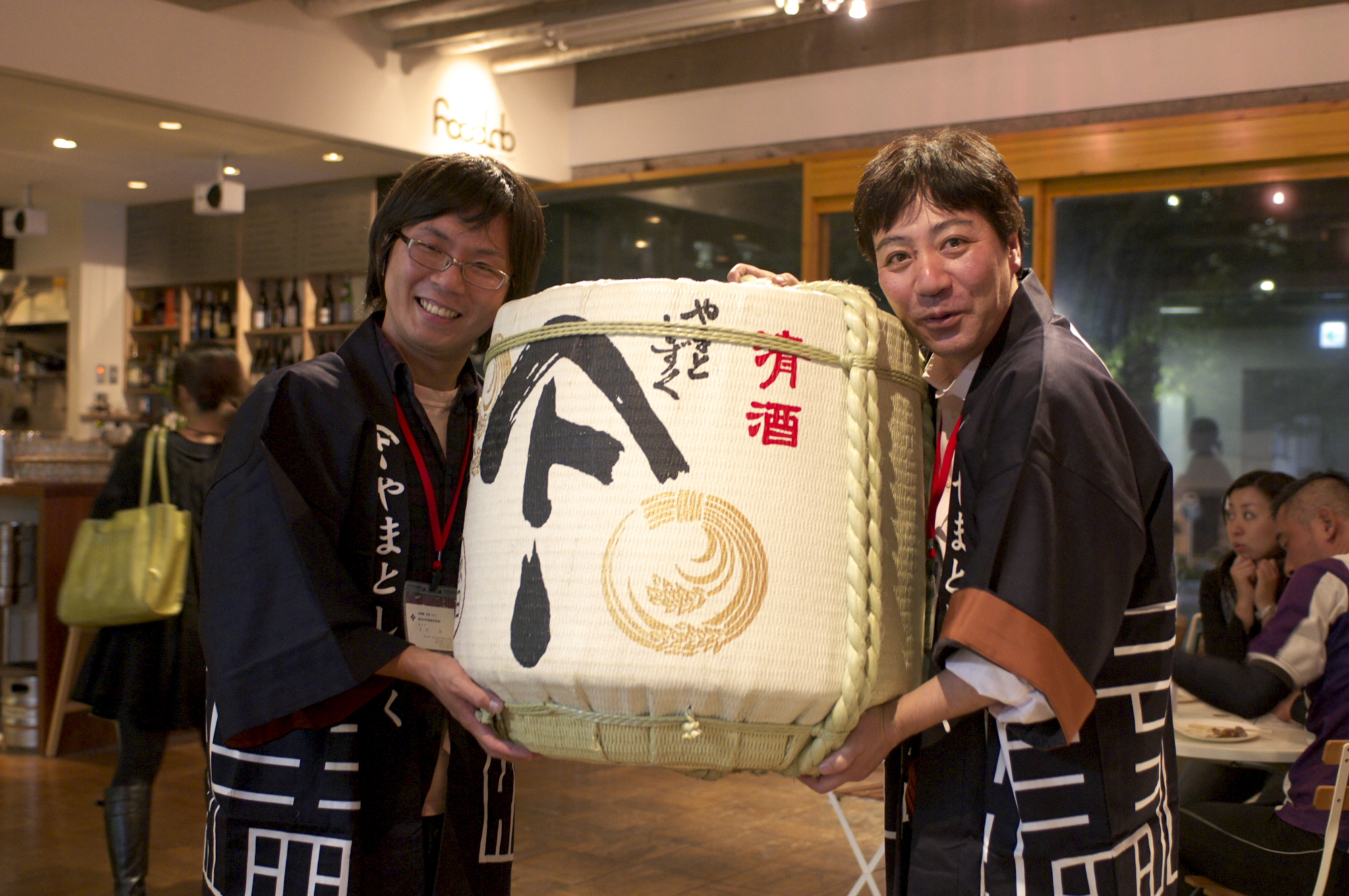 菰樽を抱えて笑顔を見せる二人